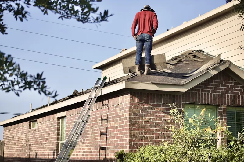 Professional roofer working on a residential roof in Country Club Trail